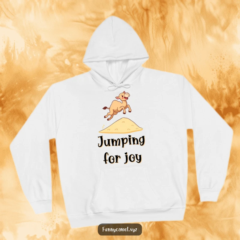 Funny determined camel leaping joyfully over a sand dune, featured on a soft, warm hoodie for cozy motivation.